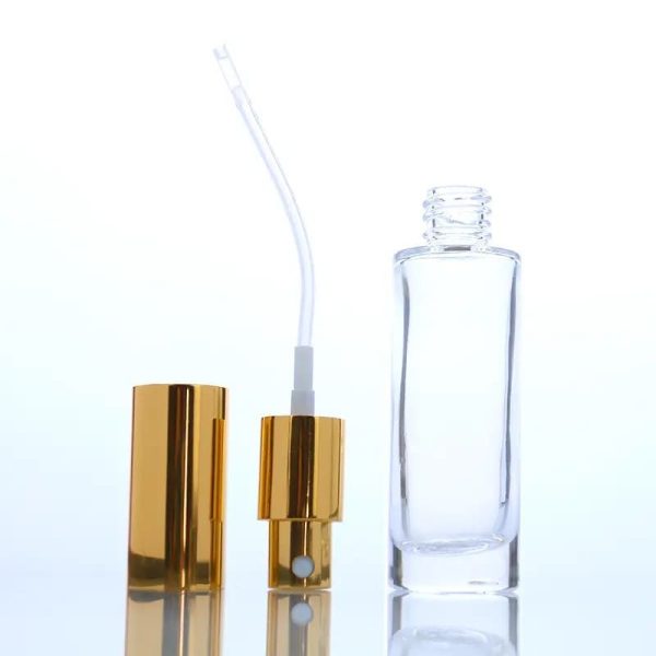 Flacon en verre transparent pour parfum avec bouchon spray dorée et épaulement plat emballage cosmetique maroc