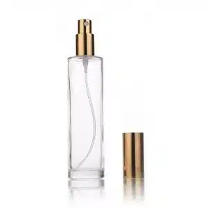 Flacon vaporisateur en verre transparent avec une pompe spray dorée et un capuchon assorti doré métallisé